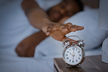 Sleepy African Man Turning Off Alarm-Clock Waking Up At Home