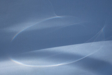 A smooth twist of blue glowing abstract lines with reflections on a  textured wall.Concept for...