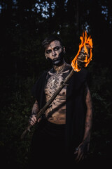 Sorcerer with marks on his body in the forest