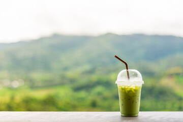 Matcha green tea with milk on plastic glass.