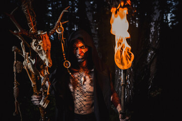 Sorcerer with marks on his body in the forest