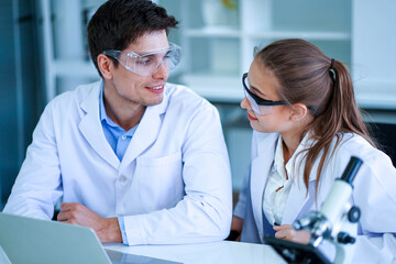 Attractive Caucasian european medical scientist working with microscope in laboratory . Health care...