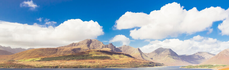 Fototapeta premium Panoramic view of Bla Bheinn (Blaven) and Cuillin Mountains on beautiful sunny day on Isle of Skye, Scotland, UK