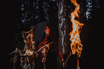 Sorcerer with marks on his body in the forest