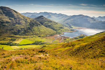 Hills and mountains under the beautiful light from within the clouds and the green hills West Highlands in Scotland, United Kingdom