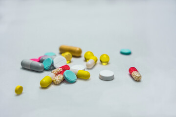 Tablets and capsules are in bulk on a white background