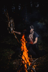 Sorcerer with marks on his body in the forest