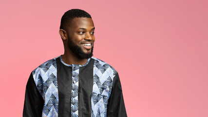 Handsome black guy in african shirt looking at copy space