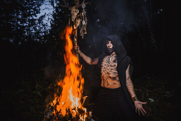 Sorcerer with marks on his body in the forest