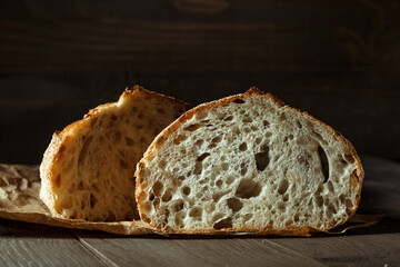 Bread, traditional sourdough bread cut into slices on a rustic wooden background. Concept of traditional leavened bread baking methods. Healthy food.