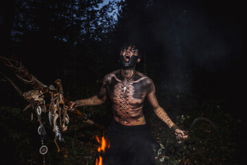 Sorcerer with marks on his body in the forest