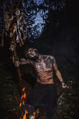 Sorcerer with marks on his body in the forest