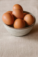 Eggs background. Closeup view of eggs in a bowl on rustic table as background. Organic and healthy food. 