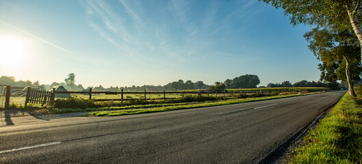 Ländliche Landstraße bei Sonnenaufgang