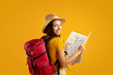 Smiling young woman tourist with backpack holding city map