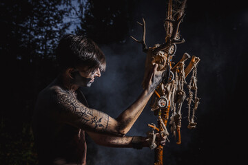 Sorcerer with marks on his body in the forest