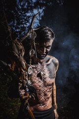 Sorcerer with marks on his body in the forest