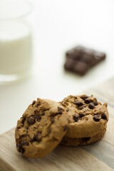 chocolate chip cookies on wood with a glass of milk 