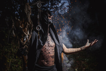 Naklejka premium Sorcerer with marks on his body in the forest