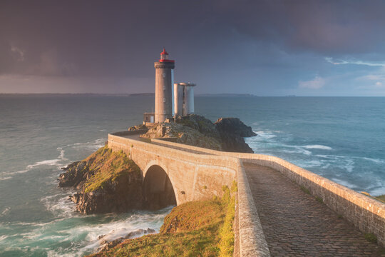 Most popular lighthouse in Europe during stormy weather. Petit Minou Lighthouse at sunset with red light, Brest , France View of Lighthouse of Petit Minou in Brittany. Summer season, France coastline