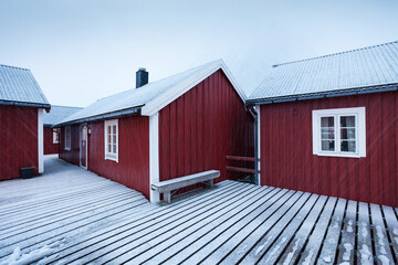 Traditional red wooden houses on the shore of Reine fjord. Beautiful winter scene of Vestvagoy...