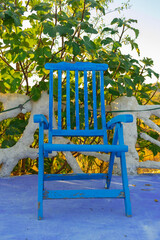 Fototapeta na wymiar Blue wooden bench seen from the front on a blue floor outdoors