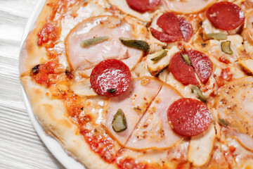 Italian pizza with ham, salami and mushrooms.
