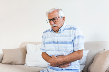 Old man having strong abdominal ache, health problems. Senior man with stomach pain