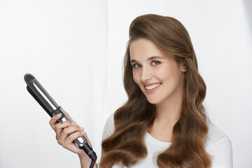 amazing girl with perfect hairstyle holding curling iron
