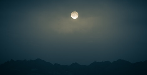Naklejka na ściany i meble Full moon over mountains in Scotland