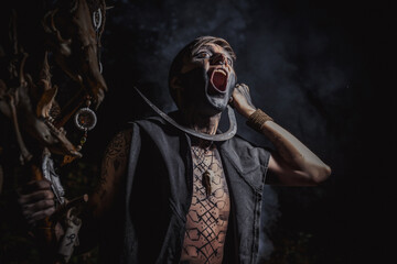 Sorcerer with marks on his body in the forest