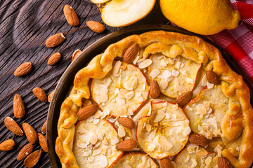 crispy apple galette with almonds on rustic wooden background