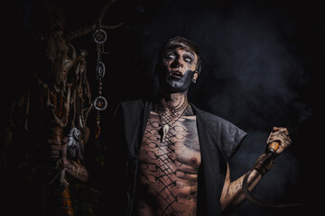 Sorcerer with marks on his body in the forest