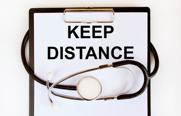 In the notebook inscription KEEP DISTANCE, around there are multi-colored tablets and thermometer.