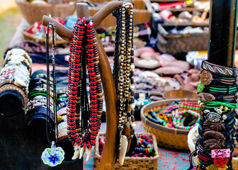 Decorations and accessories of different colors on the table. Beads, bracelets, watches on the table. Sale at the fair. Boho.