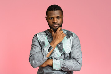 Portrait of serious black guy in traditional clothes