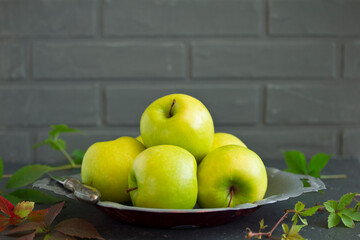 Green apples in a gray cup. Selective focus.