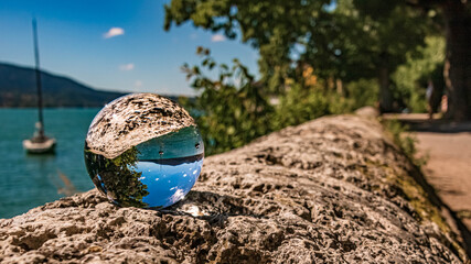 Crystal ball alpine landscape shot with a boat at the famous Tegernsee, Bavaria, Germany