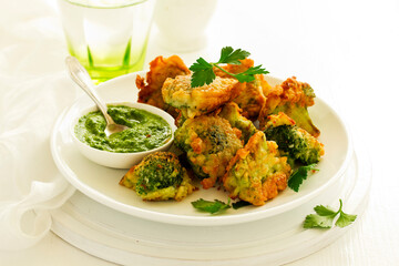 Fried broccoli in batter with green sauce. Selective focus