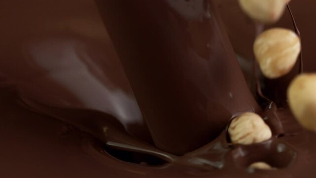 Super slow motion of falling hazelnuts into dark hot chocolate. Filmed with cinema high speed camera, 1000fps.