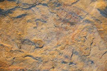 Details of sand stone texture, closeup shot of rock surface with vignette at cover and bright spot at centre, idea for background or backdrop.