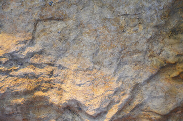 Details of sand stone texture, closeup shot of rock surface with vignette at cover and bright spot at centre, idea for background or backdrop.