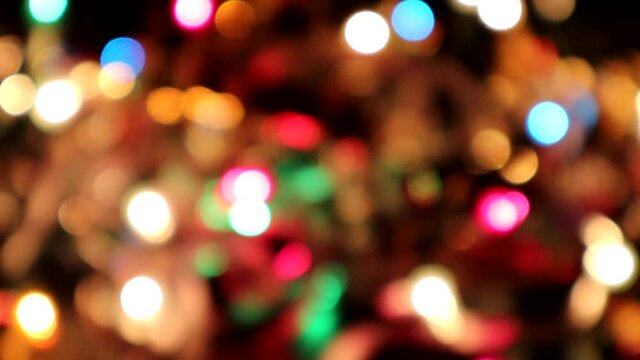 Bokeh effect of blurred holiday lights twinkling in tinsel for a festive background