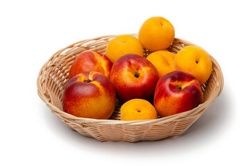 nectarine, peach and plums in a wicker basket on a white background