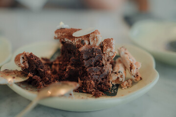 Close upeating a chocolate brownie in a coffee shop.