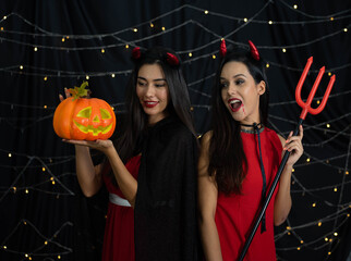Caucasian woman wearing witch costume in Halloween festival party with black background and light