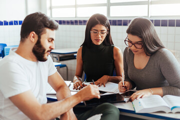 Multiethnic group of college students talking in classroom.