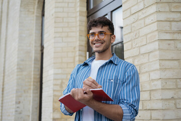 Happy asian business man writing on notebook, working project. Smiling university student studying,...