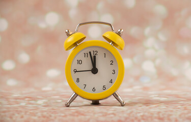yellow alarm clock, time five minutes 12