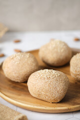 Fototapeta na wymiar Gluten free Keto bread. Homemade ketogenic buns with sesame seeds. set on white cafe table.